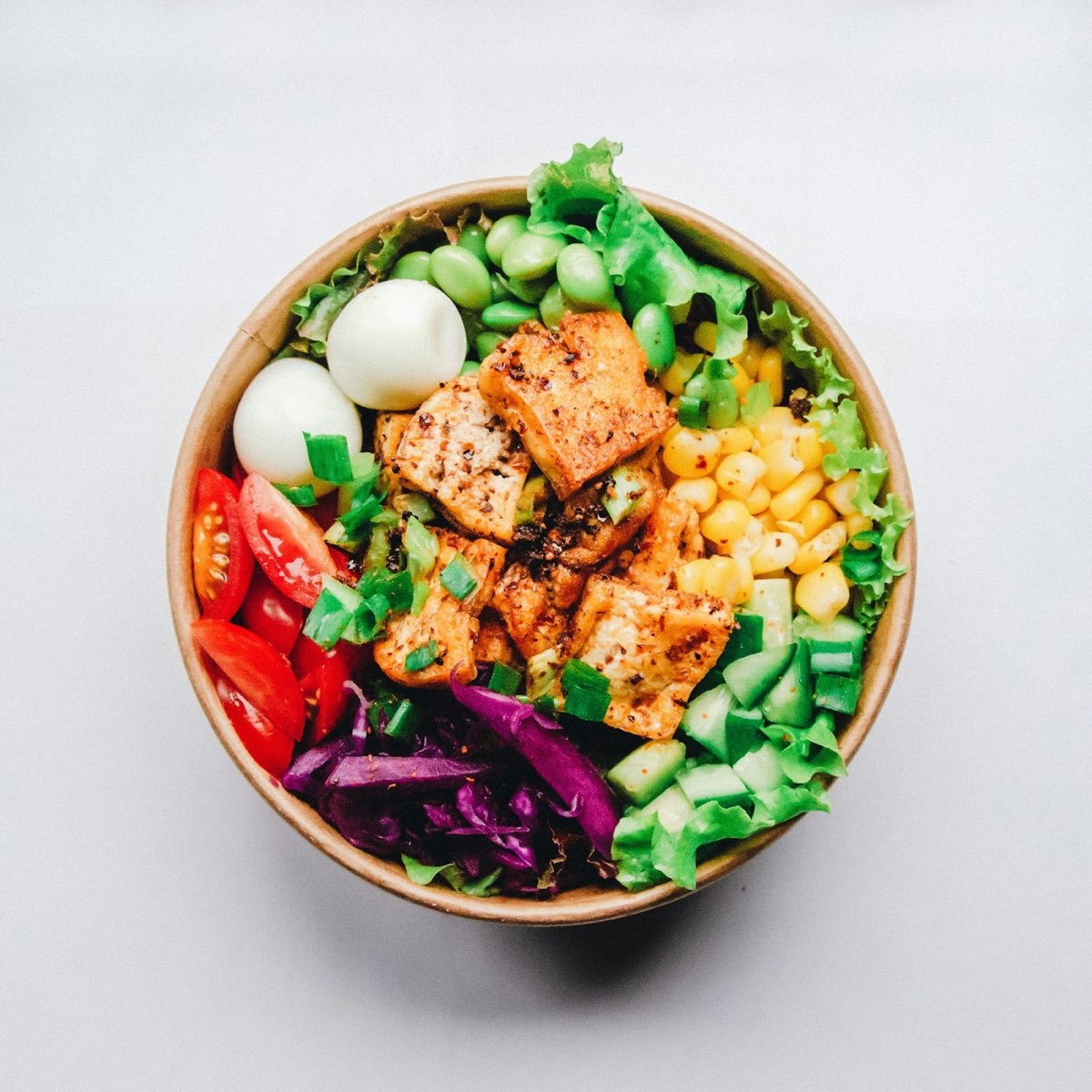 Colourful salad bowl with greens, corn, tomato and egg